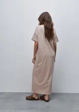 Vestido midi negro de algodón con calce relajado, silueta recta, cuello redondo, mangas cortas amplias y tajos laterales.