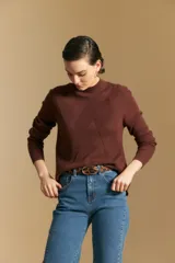 Polera de cuello alto en color blanco, confeccionada en tejido acanalado con un diseño geométrico de relieve que crea un efecto visual estilizado. Presenta un corte al cuerpo y mangas largas, ideal para usar como prenda base o principal.