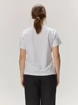 Remera negra de manga corta con cuello redondo y detalle de bordado floral en tono tostado en la parte inferior derecha.