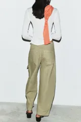 Pantalón cargo de tiro medio confeccionado en algodón, con diseño de pierna ancha, cintura con trabillas, bolsillos delanteros y bolsillos de plastrón con solapa en la pierna.