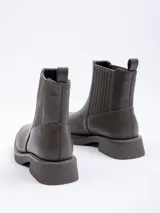 Bota tipo Chelsea de símil cuero color suela, con plataforma oscura, punta cuadrada y paneles elásticos laterales.