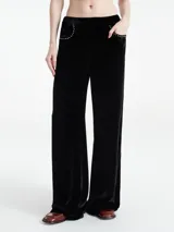 Pantalón ancho de terciopelo negro con bolsillos laterales y cintura elástica.