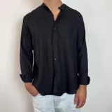 Camisa de manga larga con cuello mao, confeccionada en lino, con corte regular y cierre frontal de botones.