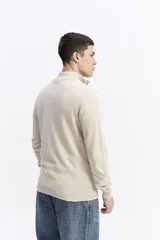 Buzo de punto con medio cierre frontal, cuello elevado y puños acanalados. Presenta un pequeño logo bordado en el pecho.