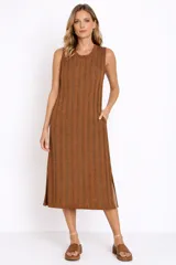 Vestido midi de punto acanalado, sin mangas, con cuello redondo y diseño holgado. Presenta aberturas laterales en el ruedo y bolsillos laterales.