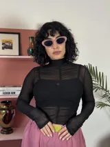 Remera de microtul negro con diseño ajustado, cuello alto y detalle de fruncido central vertical.