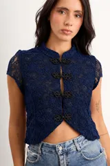 Top de encaje color azul marino, de manga corta y cuello mao, con cierre frontal mediante broches decorativos estilo nudo chino.