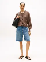 Cárdigan marrón de punto de algodón, con cuello redondo, cierre frontal con botones, mangas globo, puños y bajo de punto canalé, y dos bolsillos delanteros diagonales.