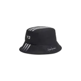 Gorro bucket Adidas Y-3 de color negro, con las icónicas tres tiras blancas en la parte superior y en el ala, el logo Y-3 y la firma de Yohji Yamamoto bordados.