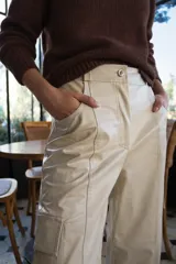 Pantalón cargo de cuerina color beige, tiro alto, corte holgado y bolsillos laterales.