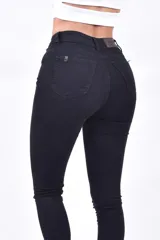 Pantalón de jean negro, tiro alto, corte ajustado y ruedo al tobillo.