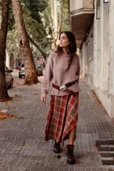 Falda midi de diseño asimétrico que combina un panel de tela escocesa en tonos verdes, blancos y marrones con un panel lateral de paño verde oscuro. Presenta un tajo lateral pronunciado y tiro a la cintura.