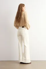 Pantalón de jean wide leg en color blanco, de tiro alto y corte ancho con dobladillo ancho en los bajos.