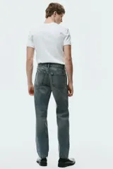 Pantalón jean de cinco bolsillos en denim de algodón rígido, con pierna recta apenas holgada y corte estándar. Cuenta con cintura clásica y cierre de botones.