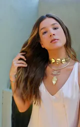 Gargantilla dorada con diseño de círculos y dije colgante con forma de hoja.