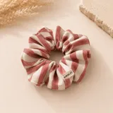 Colero tipo scrunchie de lino con diseño de rayas verticales en color rosado y beige. Incluye una pequeña etiqueta de tela con la marca Amalfi.