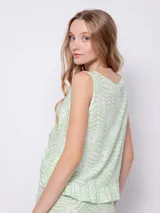 Blusa sin mangas de tela fluida con estampado floral en blanco y negro. Cuenta con jareta para fruncir en la parte delantera central.