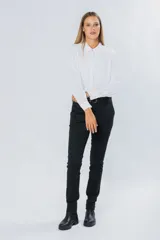 Pantalón de gabardina azul marino, de corte skinny y tiro medio, con bolsillos laterales y trabillas para cinturón.