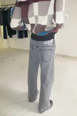 Pantalón de jean negro de corte recto y tiro medio, con cierre frontal de botón y cremallera, y bolsillos laterales y traseros.