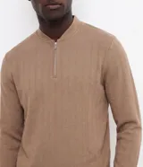 Remera manga larga beige con textura vertical en relieve y cierre frontal parcial en el cuello, confeccionada en mezcla de algodón y poliéster.
