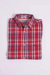 Camisa de manga corta con diseño a cuadros en tonos rojos, blancos y azules. Presenta cuello clásico, cierre frontal con botones y logo bordado en el pecho. Corte slim fit.