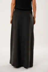 Falda larga negra confeccionada en tela suave con acabado tipo piel de durazno y cierre invisible lateral.