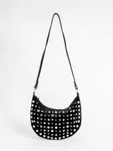 Cartera tipo bandolera de gamuza negra en forma de media luna, completamente decorada con tachas metálicas plateadas de distintos tamaños. Cuenta con un asa ajustable para llevar al hombro o en la mano y cierre superior con cremallera.