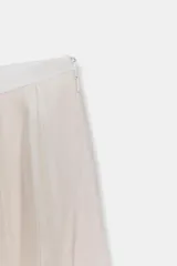Falda midi de tiro medio de la colección ZARA Woman, confeccionada en mezcla de lyocell con acabado fluido y bajo en línea evasé. Cuenta con forro interior a tono y cierre lateral con cremallera oculta.