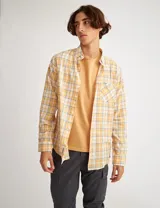 Camisa de manga larga a cuadros amarillos, blancos y grises, con bolsillo en el pecho y botones de pasta.