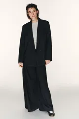 Blazer oversize de corte recto con estampado de raya diplomática, cuello con solapas de muesca, hombreras, manga larga y cierre frontal con botones. Cuenta con bolsillos de vivo en el delantero y forro interior.