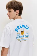 Remera blanca de algodón con cuello redondo, manga corta y pequeño estampado en el pecho.