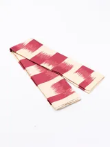 Pañuelo de seda o material similar, estampado con patrón de leopardo en tonos marrones y negros, con borde liso negro.