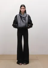 Pantalón de vestir negro estilo flare de tiro medio, con trabillas y cierre frontal con botón, gancho y cremallera.