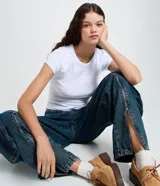 Pantalón cargo de jean azul con corte loose, cintura baja, múltiples bolsillos laterales estructurados y cierre funcional en el ruedo.