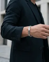 Pulsera de acero con eslabones gruesos y placa central rígida con detalle de circonia.