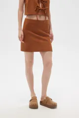 Minifalda marrón de poliéster con corte recto y abertura lateral.