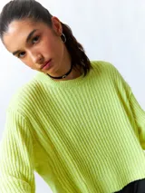 Sweater color crema de tejido de punto acanalado, corte cropped, cuello redondo y mangas largas.