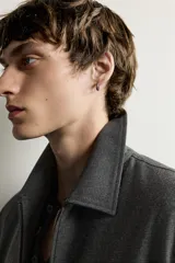 Sobrecamisa regular fit color gris, con cuello solapa, manga larga con puño abotonado, bolsillos de vivo en la cadera y cierre frontal con cremallera de doble dirección.