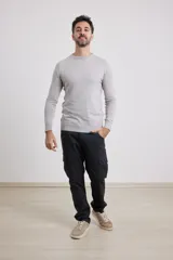 Sweater de punto liso, color azul, con escote redondo y manga larga.