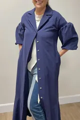 Vestido largo azul con cuello camisero, abotonado al frente, mangas 3/4 abullonadas y falda con volantes.