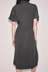 Vestido midi de corte camisero color gris, confeccionado con mezcla de lyocell y lino. Presenta cuello solapa, manga corta, pliegues en la cintura y cierre frontal con botones ocultos.