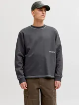 Buzo gris oscuro de manga larga con cuello redondo, calce relajado, costuras visibles en contraste y pequeño estampado con el logo en el pecho.