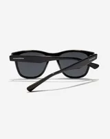Lentes de sol unisex Hawkers, modelo One Pair, con montura rectangular negra y lentes polarizadas grises.