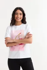 Remera de algodón color beige con cuello redondo y mangas cortas con dobladillo. Presenta un estampado frontal rectangular en color rosa con el texto en relieve 'PINK IS ALWAYS AN OPTION'.