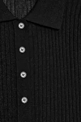 Jersey de punto semitransparente color negro, con cuello polo, manga corta y cierre frontal de botones.