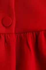 Top rojo de manga corta con escote redondo, botones forrados adelante y peplum.