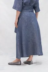 Falda midi color marrón de lino con bolsillos laterales y volante en el ruedo. Tiene una tira en la cintura para anudar en la delantera.