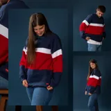 Buzo de felpa azul marino, rojo y blanco con diseño de bloques de color.