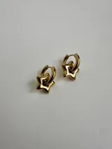 Aros de acero quirúrgico dorado con diseño 2 en 1, compuestos por una argolla pequeña y un dije colgante en forma de estrella abombada.