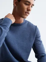 Sweater azul de lana merino con cuello redondo y logo bordado en el pecho.